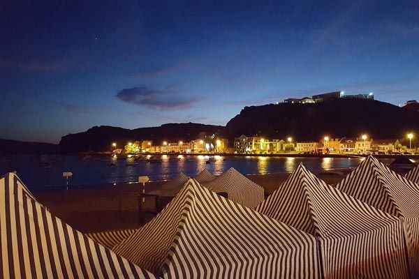 Night view of Sao Martinho do Porto beach with lights on the dock